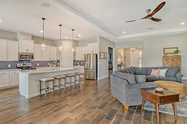 living room featuring recessed lighting, ceiling fan with notable chandelier, wood finish floors, visible vents, and baseboards