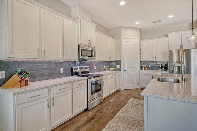 kitchen with stainless steel appliances, dark wood-type flooring, a sink, visible vents, and white cabinets