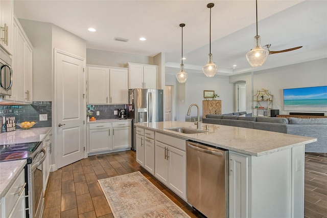 kitchen with white cabinets, wood tiled floor, stainless steel appliances, and a sink