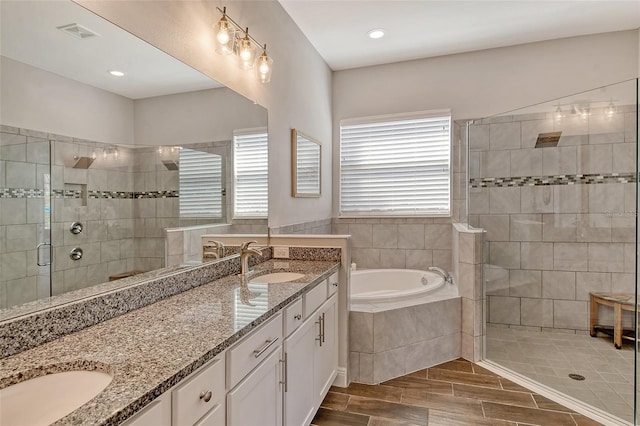 full bath with double vanity, a stall shower, visible vents, and a sink