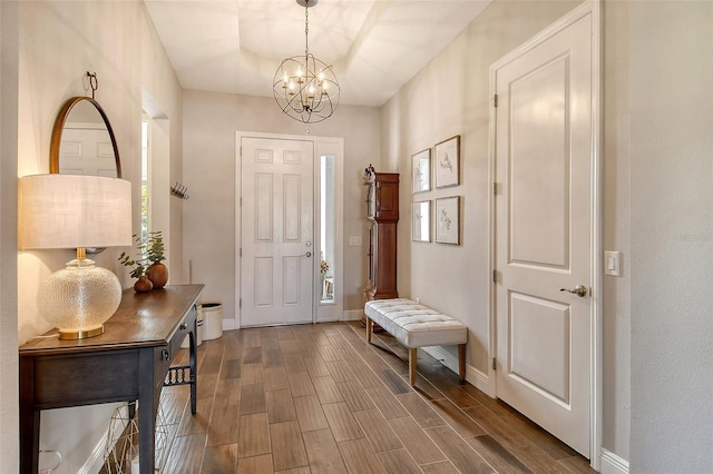 foyer featuring a chandelier, wood finish floors, and baseboards