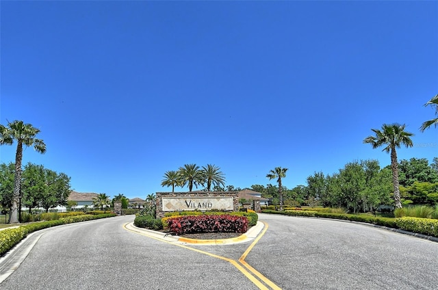 view of road with a gated entry and curbs