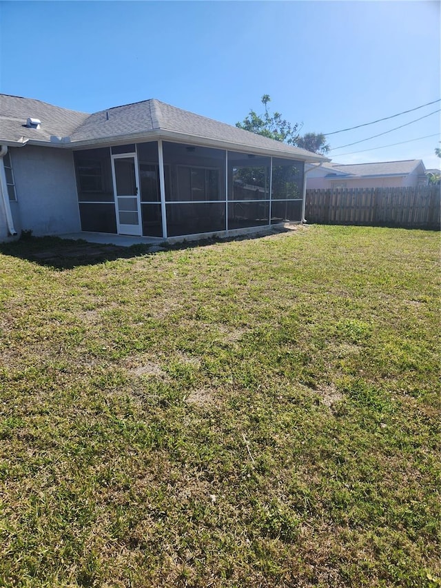 view of yard featuring fence and a sunroom