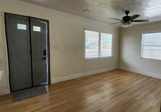 foyer entrance featuring ornamental molding, plenty of natural light, and light wood finished floors