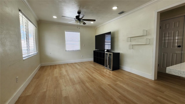 unfurnished living room featuring crown molding, light wood-style flooring, and baseboards