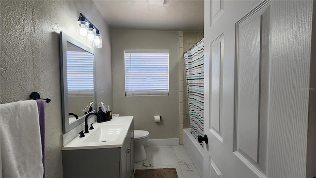 full bath with marble finish floor, shower / tub combo with curtain, toilet, vanity, and baseboards