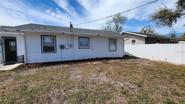 rear view of house featuring fence