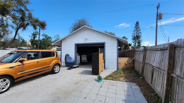 detached garage with driveway and fence