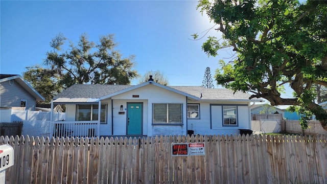 view of front of home with a fenced front yard and a porch