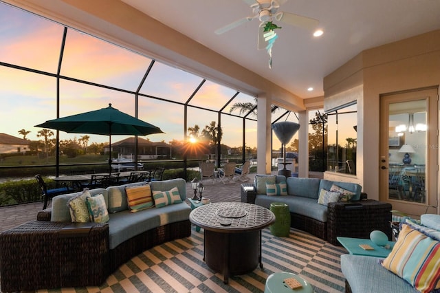 view of patio / terrace with outdoor dining space, glass enclosure, ceiling fan, and an outdoor living space