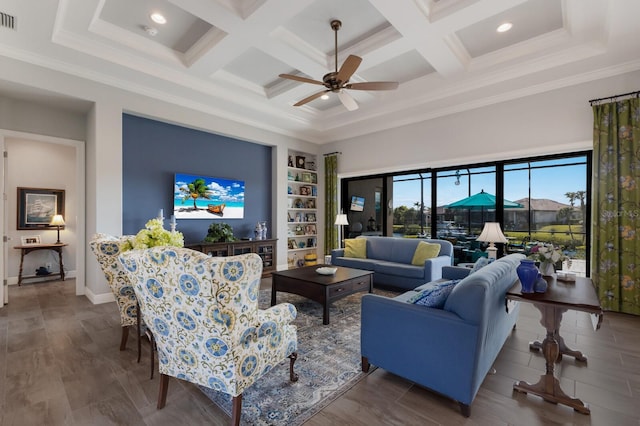 living area featuring a towering ceiling, visible vents, coffered ceiling, and crown molding