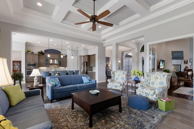 living room featuring a high ceiling, ornamental molding, coffered ceiling, and wood finished floors