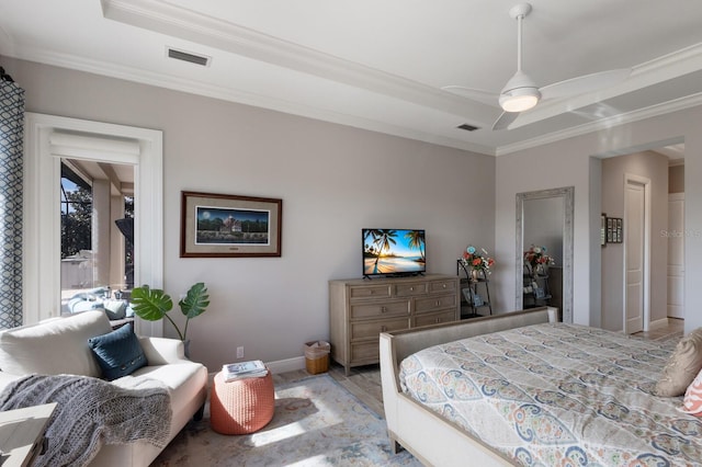 bedroom with ornamental molding, a raised ceiling, visible vents, and baseboards