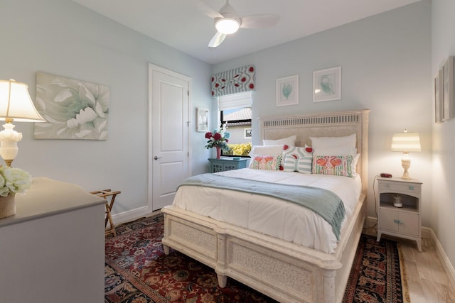 bedroom with a ceiling fan, baseboards, and wood finished floors