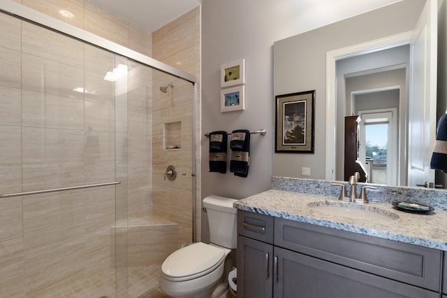 full bathroom with a shower stall, toilet, and vanity