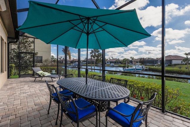 view of patio with a lanai, a water view, and outdoor dining area