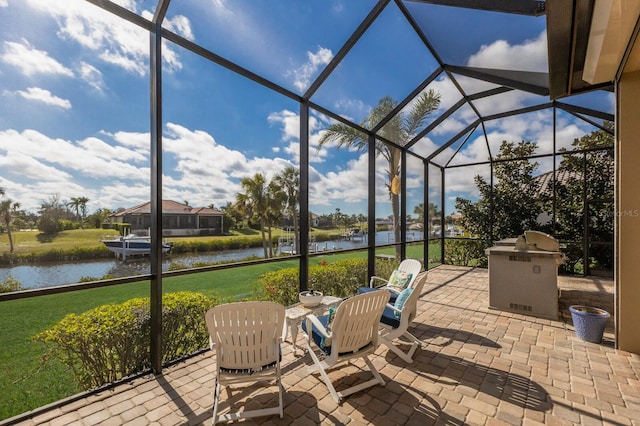 view of patio / terrace featuring a lanai and a water view