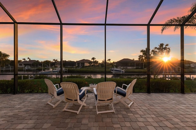 patio terrace at dusk with glass enclosure and a water view