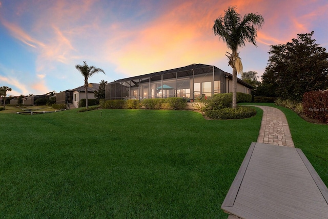 yard at dusk featuring glass enclosure