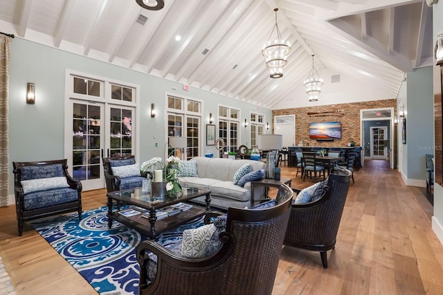 living area featuring high vaulted ceiling, visible vents, beamed ceiling, and wood finished floors