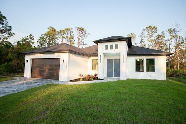 prairie-style home featuring a garage, a front lawn, decorative driveway, and stucco siding