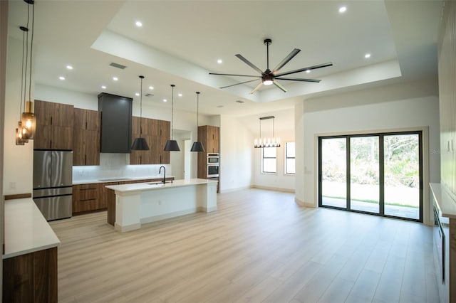 kitchen featuring modern cabinets, appliances with stainless steel finishes, a raised ceiling, and light countertops