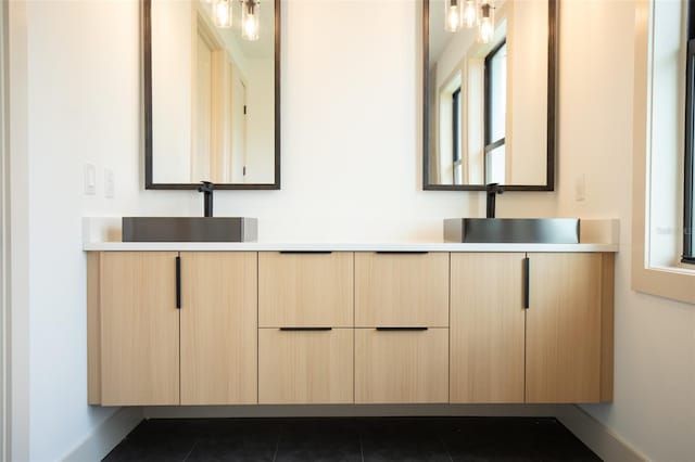 bathroom with double vanity, tile patterned flooring, and a sink