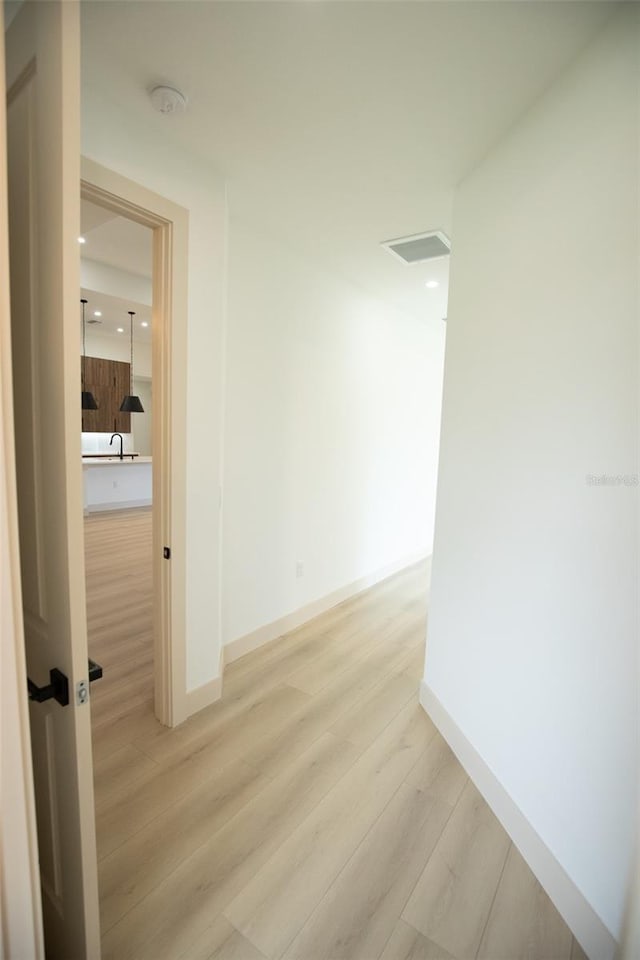 hall featuring baseboards, recessed lighting, visible vents, and light wood-style floors