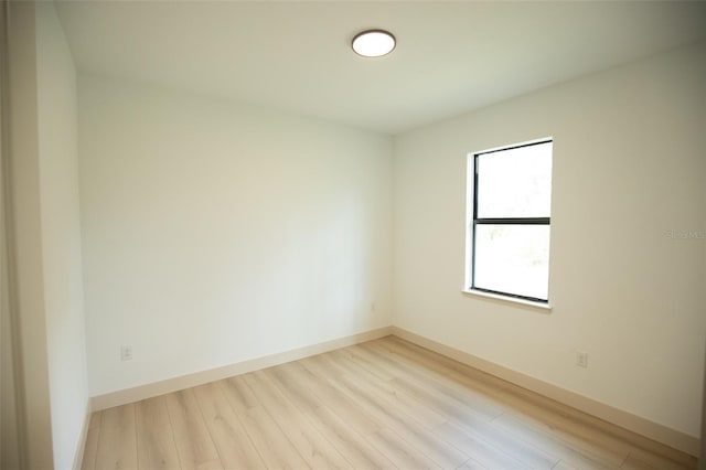 spare room with light wood-type flooring and baseboards