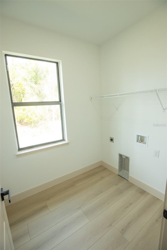 washroom with laundry area, baseboards, hookup for an electric dryer, light wood-type flooring, and washer hookup