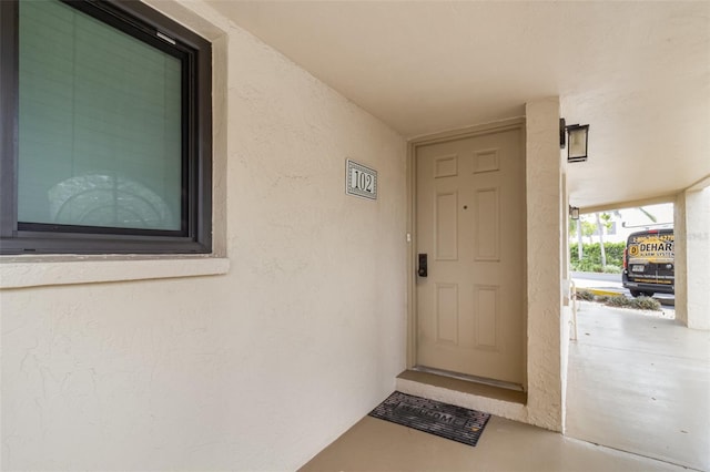 doorway to property featuring stucco siding