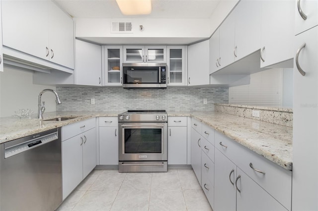 kitchen featuring decorative backsplash, a sink, stainless steel appliances, and visible vents