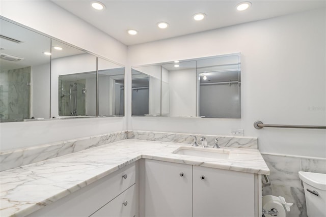 bathroom with toilet, visible vents, vanity, and recessed lighting