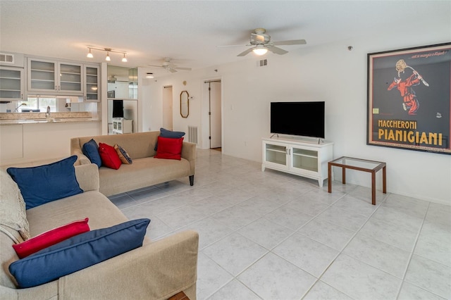 living area featuring light tile patterned floors, ceiling fan, and visible vents