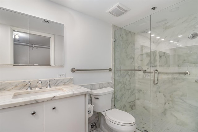 full bathroom with tile walls, toilet, vanity, visible vents, and a marble finish shower