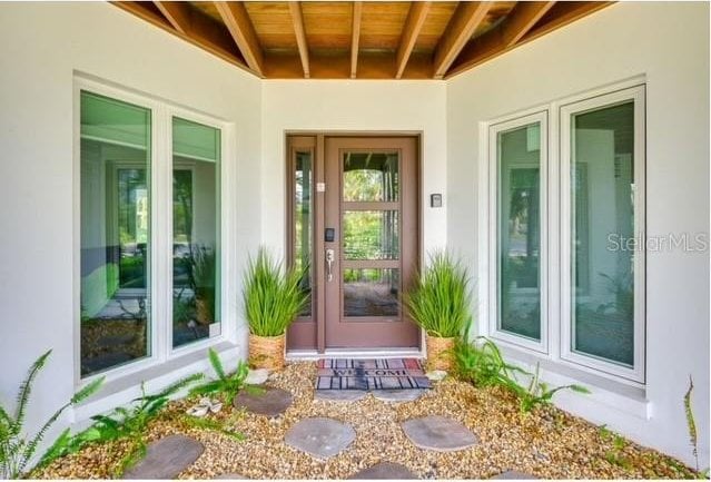 doorway to property featuring stucco siding