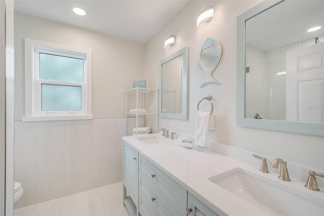 full bath with a shower, double vanity, a sink, and tile patterned floors