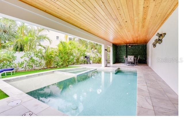 view of pool with a pool with connected hot tub and a patio area