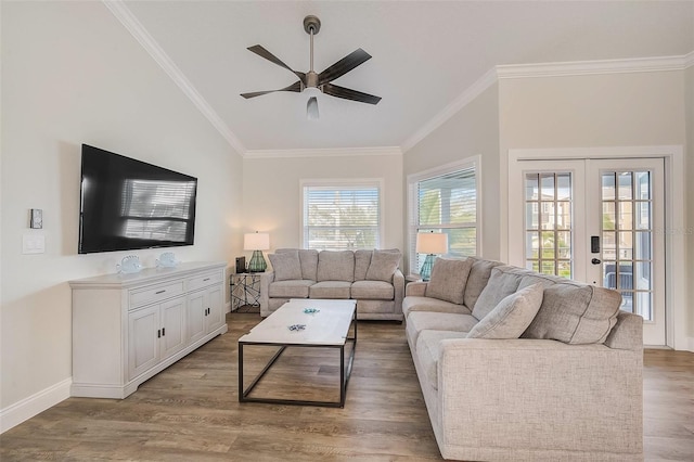 living area with light wood-style flooring, ornamental molding, ceiling fan, and french doors