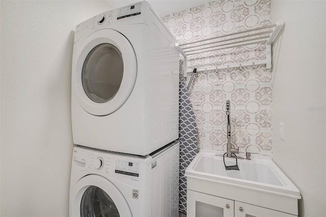 laundry room featuring stacked washer and dryer, laundry area, and a sink