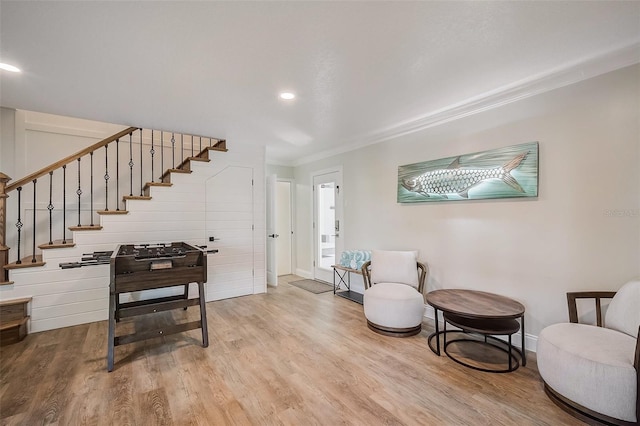 sitting room featuring recessed lighting, ornamental molding, wood finished floors, baseboards, and stairs