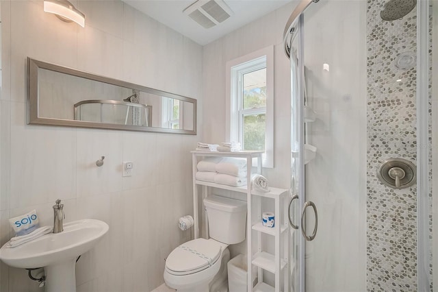 bathroom featuring toilet, a shower stall, and visible vents