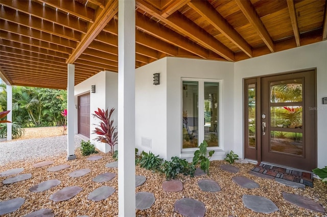 view of exterior entry featuring a garage and stucco siding