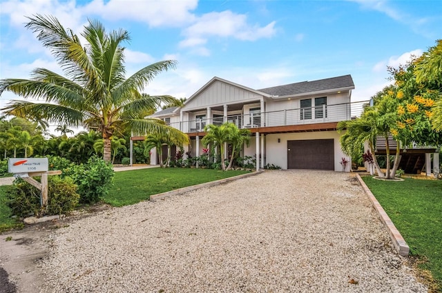 view of front of house featuring driveway, a balcony, an attached garage, and a front lawn