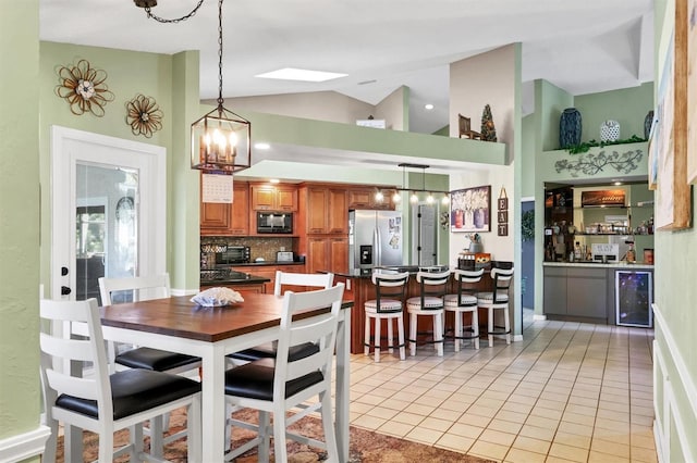 dining space with beverage cooler, high vaulted ceiling, light tile patterned flooring, and bar