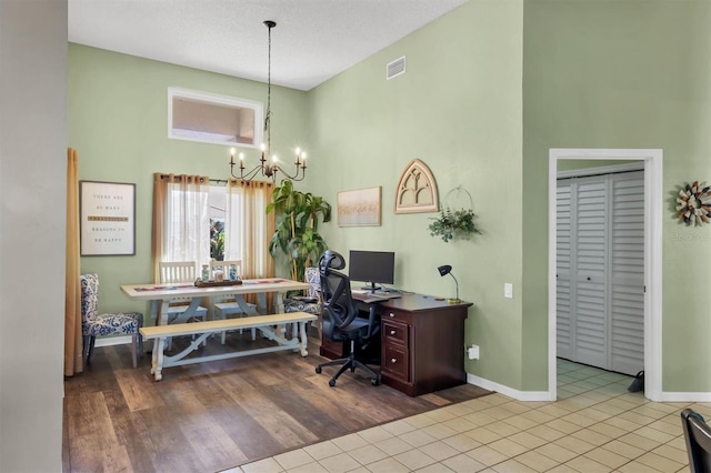 office area featuring a notable chandelier, high vaulted ceiling, visible vents, and baseboards