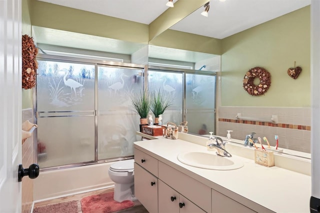 full bath with toilet, combined bath / shower with glass door, and vanity