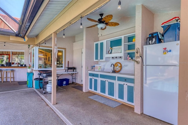 view of patio / terrace featuring glass enclosure, a sink, and a ceiling fan