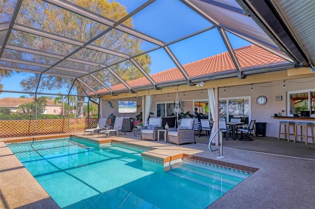 outdoor pool featuring glass enclosure, a patio, and outdoor dry bar