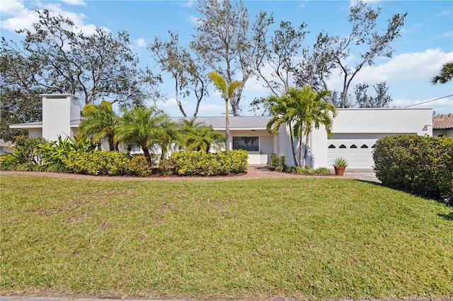 view of front of home featuring driveway, a front lawn, an attached garage, and stucco siding